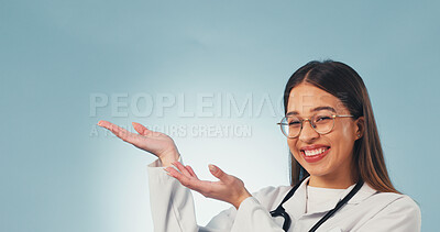 Buy stock photo Doctor, portrait and happy woman in studio, offer and recommendation for healthcare service or point. Blue background, medical expert and person with smile, space and promotion with health options