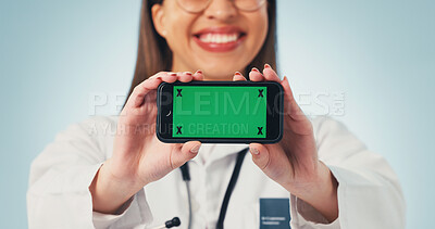 Buy stock photo Green screen, doctor and hands with phone, healthcare advertising or telehealth on blue background. Happy woman, mobile and medical worker with display for mockup space, marketing or promo in studio