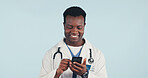 Happy, black man and doctor with phone in studio with telehealth, consultation or texting on app. Smile, reading and healthcare worker with cellphone for medical research on blue background by space.