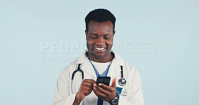 Buy stock photo Happy, black man and doctor with phone in studio with telehealth, consultation or texting on app. Smile, reading and healthcare worker with cellphone for medical research on blue background by space.