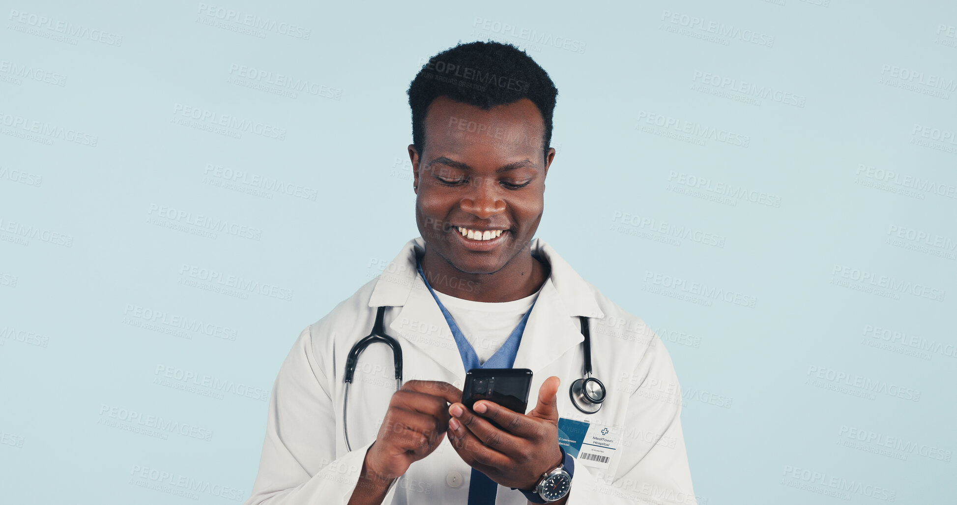 Buy stock photo Happy, black man and doctor with phone in studio with telehealth, consultation or texting on app. Smile, reading and healthcare worker with cellphone for medical research on blue background by space.