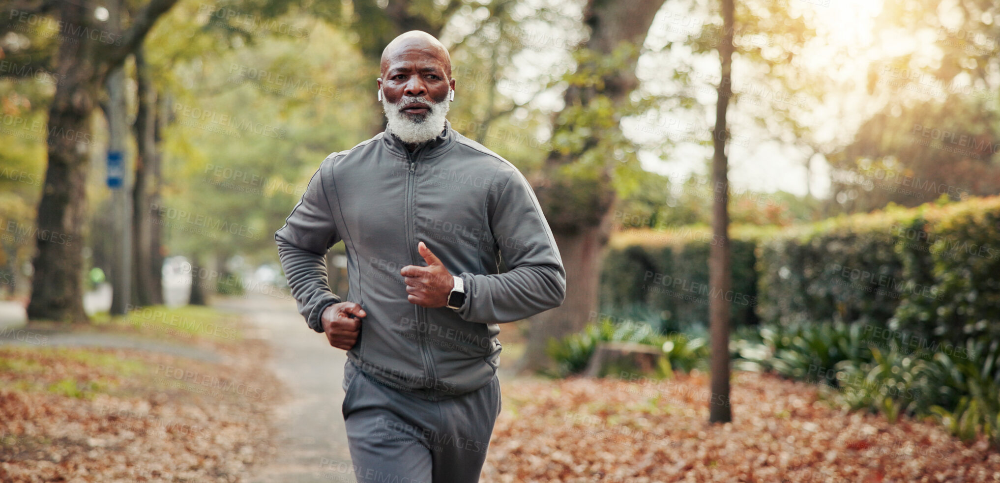 Buy stock photo Outdoor, man and running with earphones, cardio and listen to music for exercise routine and fitness. Streaming, song and black person with technology on road, mature runner and workout for wellness