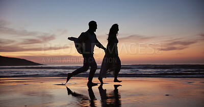 Buy stock photo Couple, running and holding hands at beach with sunset, travel and romantic date on holiday. Silhouette, smile or people at seashore with space, commitment and tropical vacation for adventure getaway