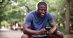 Fitness, headphones and man with phone on break, laughing and texting with smile on social media app. Happy, athlete and black person with mobile for workout update, message and listening to music