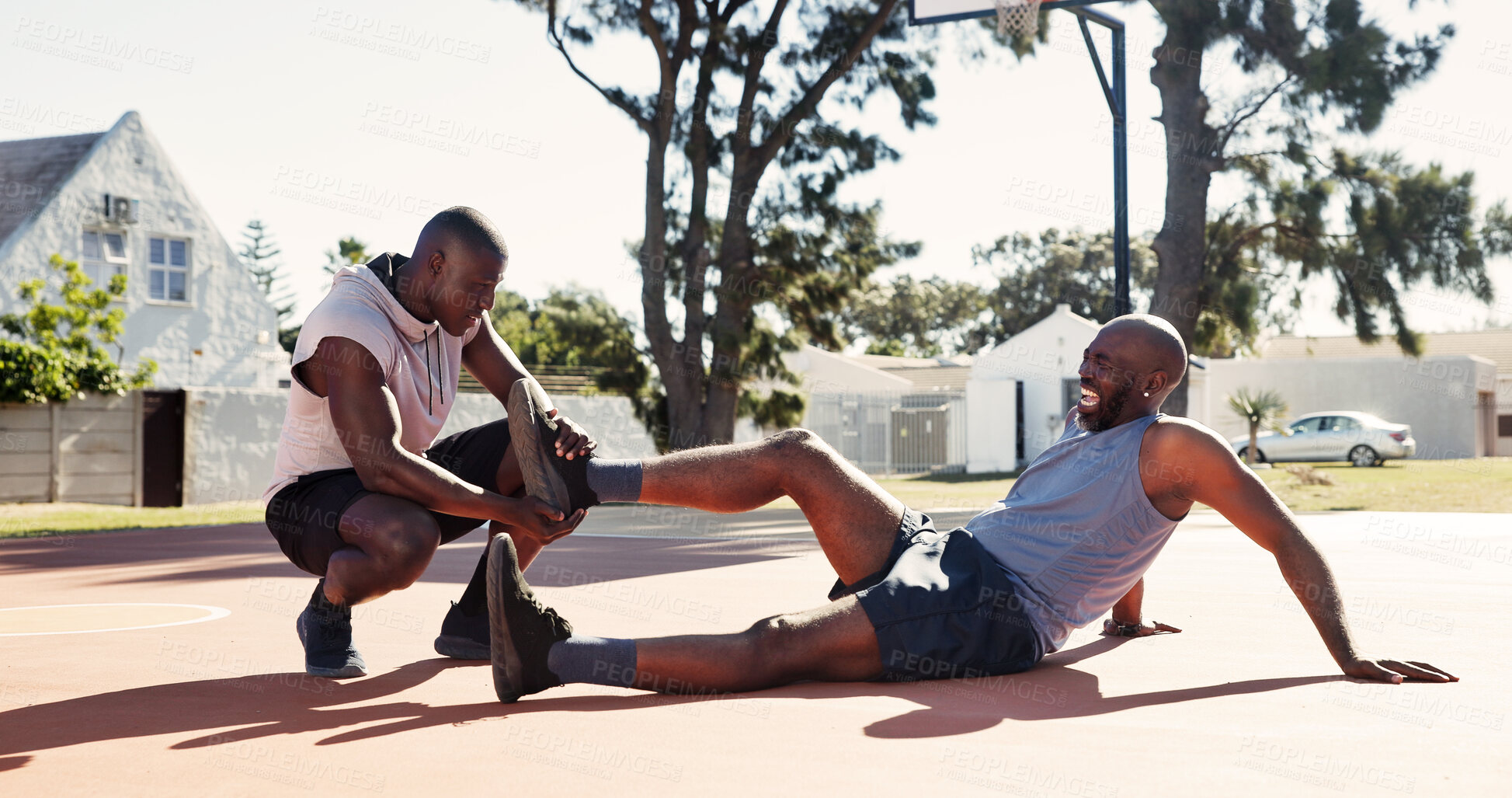 Buy stock photo Basketball court, help and black man with leg accident, pain or support with first aid outdoor. Game, African friends and player with sports injury on ground for fitness, training and muscle cramp