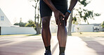 Hands, person and knee pain with accident on basketball court for exercise, fitness or training injury. Park, sports athlete and massage muscle for fibromyalgia, arthritis or health crisis outdoor