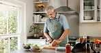 Senior, man and cooking in kitchen with vegetables, tablet and healthy food for retirement wellness. Elderly person, meal prep and chop in home with ingredients, nutrition and tech for lunch recipe.