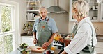 Cooking, food and old couple in kitchen with orange juice, discussion and wellness for retirement. Married, senior people and conversation in home with drink, nutrition and vegetables for meal prep.