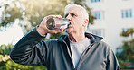 Fitness, drink and senior man in city for rest, workout recovery and hydration with bottle. Exercise break, active retirement and person with water for health, beverage and thirsty with runner