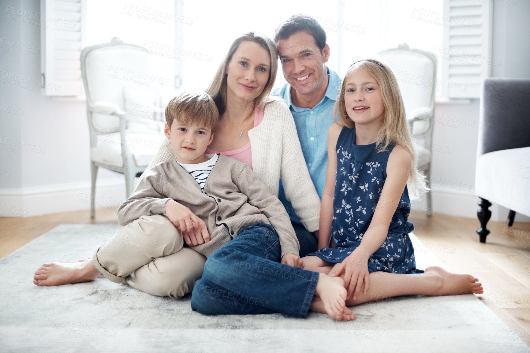 Buy stock photo Portrait, parents and relax at house with children, love and parental support for bonding together. Smile, people and resting in lounge with kids, comfortable and family connection for weekend break