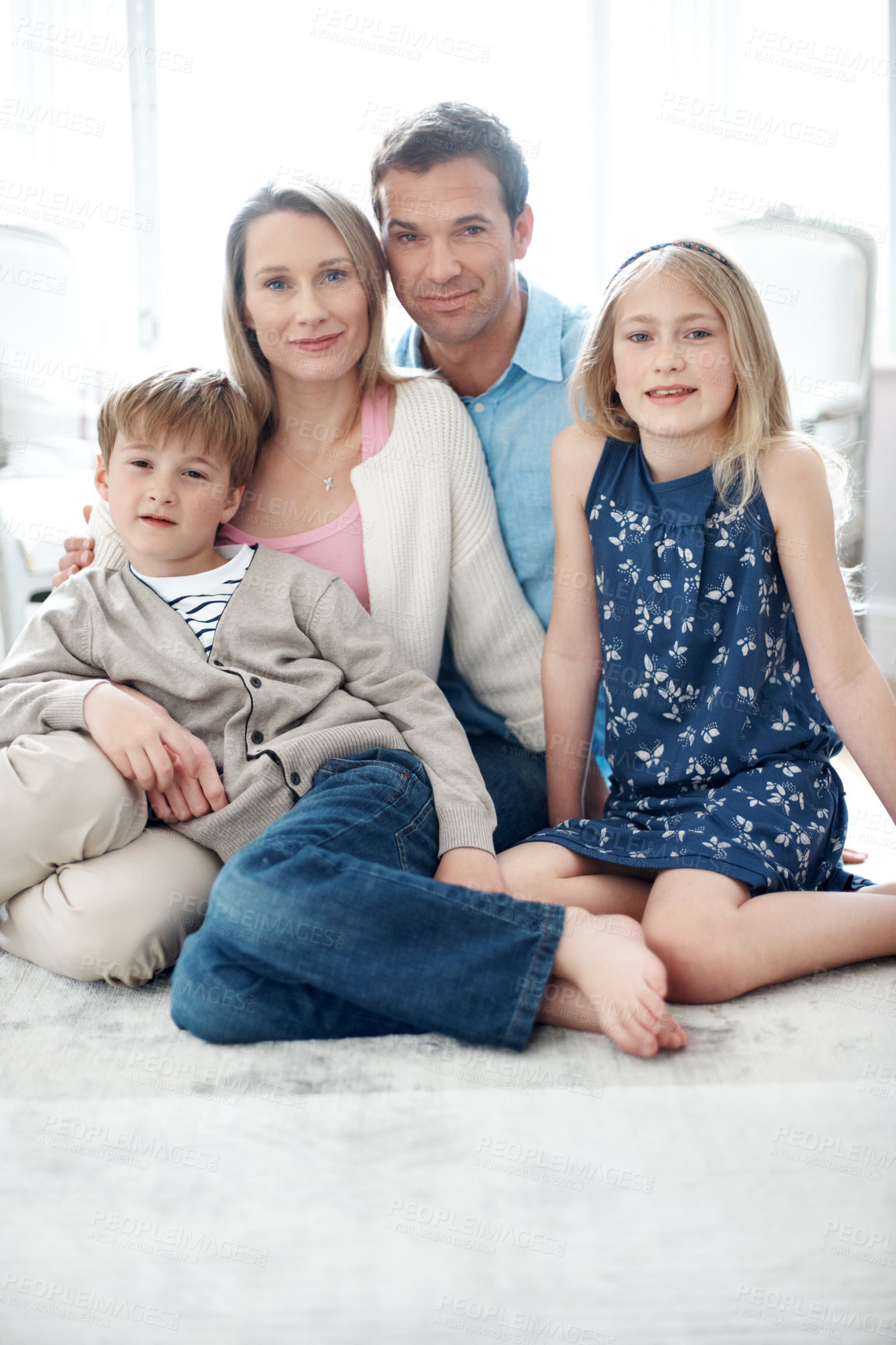 Buy stock photo Portrait, parents and relax in home with children, love and parental support for bonding together. Smile, people and happiness in lounge with kids, comfortable and family connection for weekend break