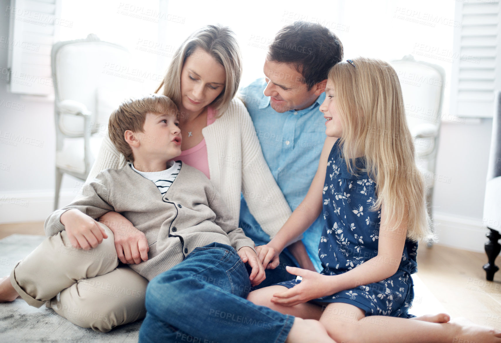 Buy stock photo Smile, parents and relax in home with children, love and parental support for bonding together. Happy, people and talking in living room with kids, comfortable and family connection for weekend break