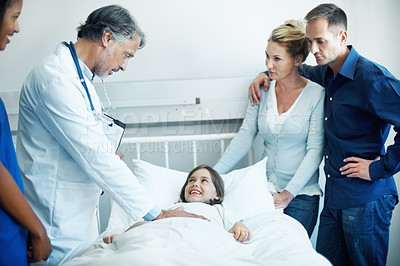 Buy stock photo Doctor, parents and checkup in hospital with sick child, wellness update and happy for virus recovery. People, mother and father in clinic with daughter, healthcare team and conversation for healing.