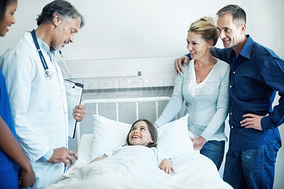 Buy stock photo Doctor, parents and talk in hospital with sick child, wellness update and happy for virus recovery. People, mother and father in clinic with daughter, healthcare team and conversation for healing.