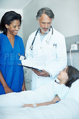 Buy stock photo Sick, child and medical team in hospital with clipboard, wellness survey and evaluation for healing. Girl, smile and consultation in clinic with healthcare people, advice and checklist for recovery.