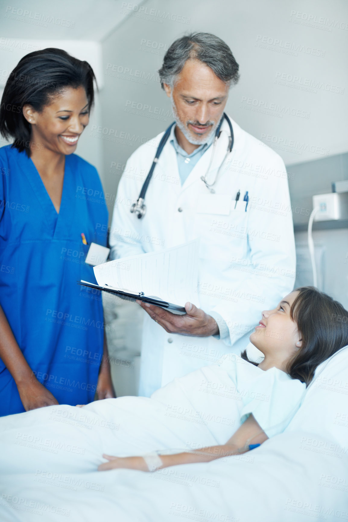 Buy stock photo Sick, child and medical team in hospital with clipboard, wellness survey and evaluation for healing. Girl, smile and consultation in clinic with healthcare people, advice and checklist for recovery.