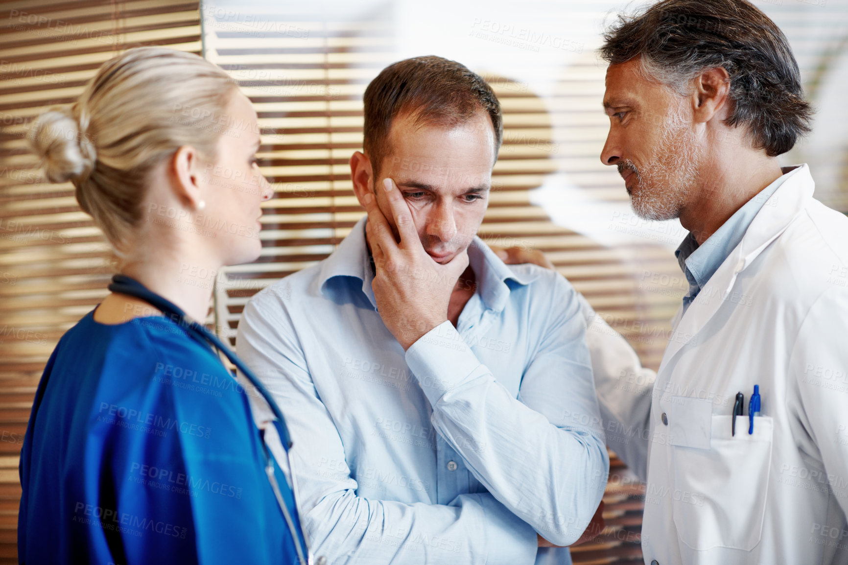 Buy stock photo Medical, team and console sad man in hospital with empathy, compassion and assurance for recovery. Doctor, nurse and worried person in clinic with stress, healthcare support or understanding emotions