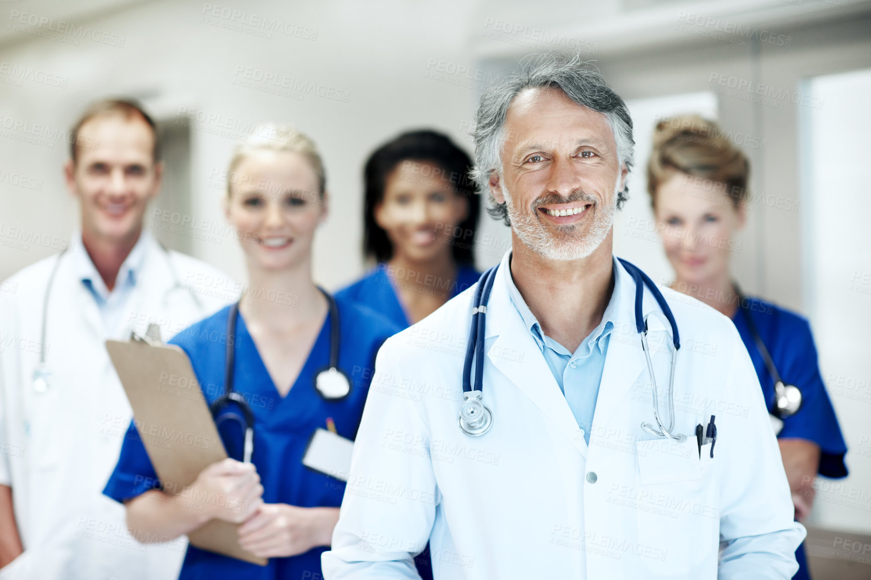 Buy stock photo Team, portrait and man with doctors in hospital for healthcare, solidarity or consulting. Medical leader, nurses and about us with people in hallway of clinic for support, community and collaboration