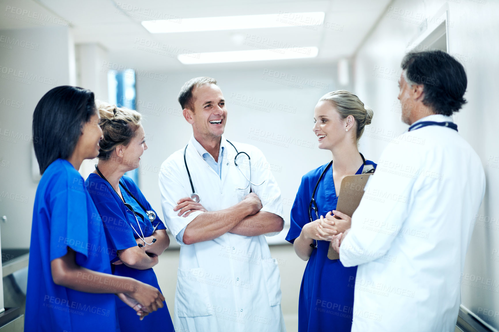 Buy stock photo Team, laugh and meeting with doctors in hospital for healthcare, solidarity and consulting. Medical, nurses and joke with group of people in hallway of clinic for support, community and collaboration