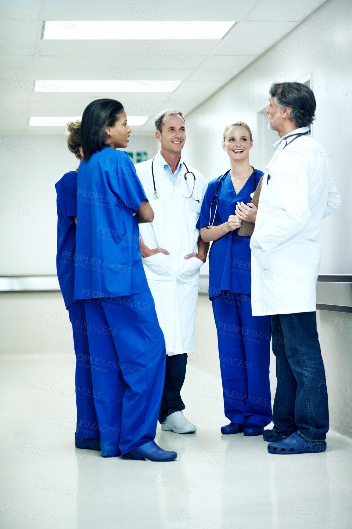Buy stock photo Team, talking and meeting with doctors in hospital for healthcare, solidarity and consulting. Medical, community and discussion with group of people in hallway of clinic for support and collaboration