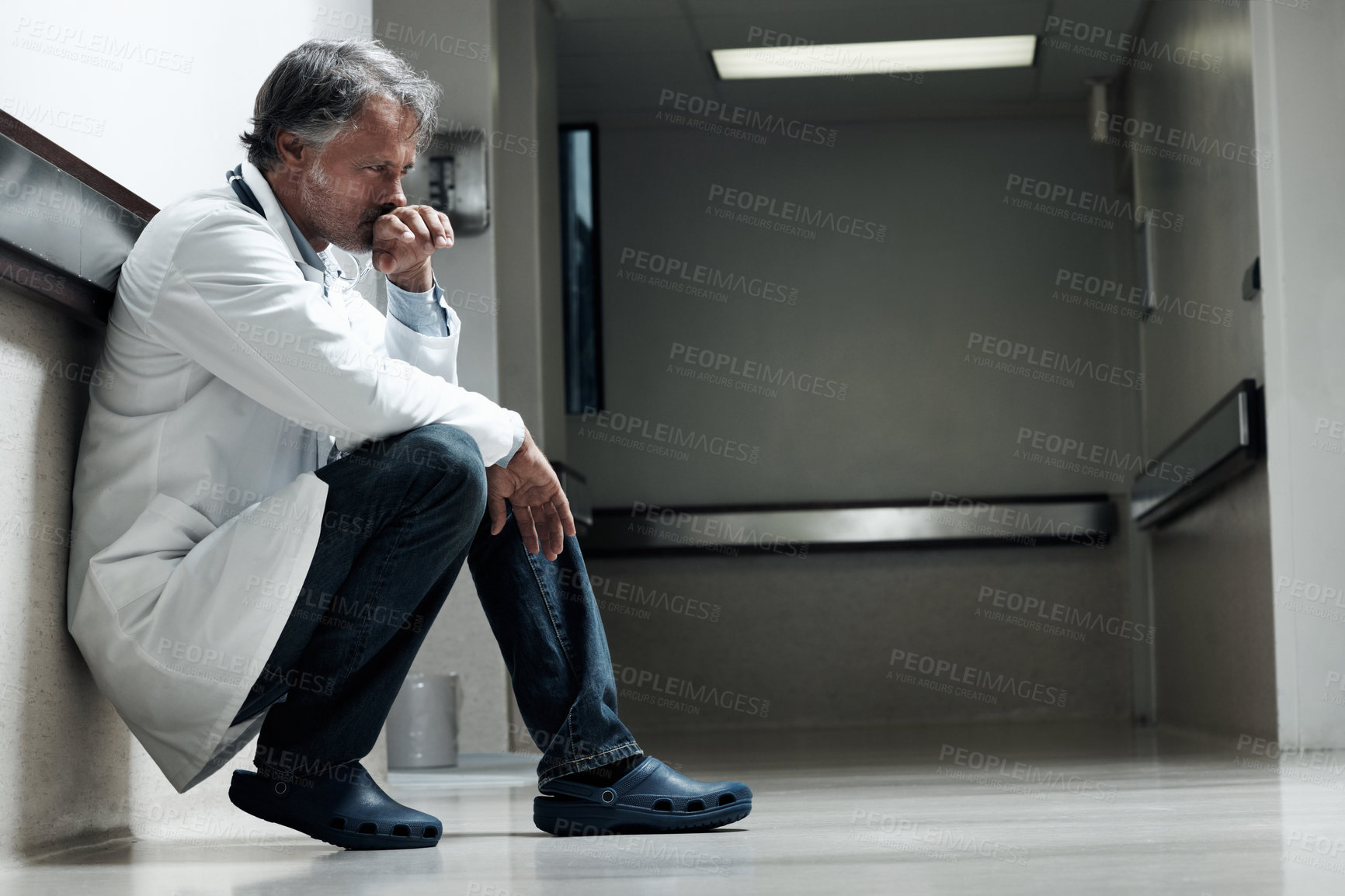 Buy stock photo Floor, sad and thinking with doctor in hospital for medical fail, reflection and emergency risk. Healthcare, career burnout and perspective with mature person with depression in hallway for error