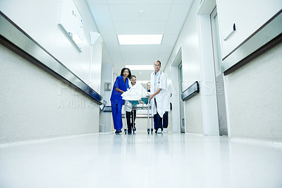 Buy stock photo Surgery, accident and team with doctors in hospital for space, medical crisis and emergency. Healthcare, injury and operation with people and patient in clinic for corridor, help and low angle
