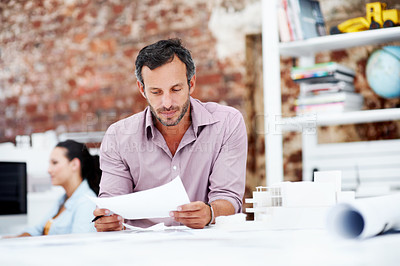 Buy stock photo Architect, man and review blueprint in office to verify building design, spatial revision or layout. Architecture staff, mature person or floor plan for property development, code compliance or draft