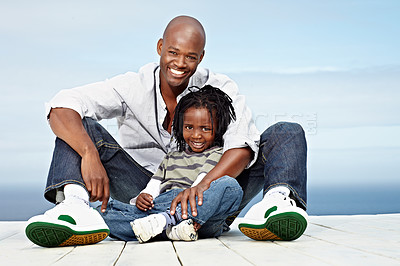 Buy stock photo Portrait of a smiling father and son sitting outside