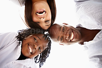 Buy stock photo Low angle portrait of a young family standing in a huddle outside