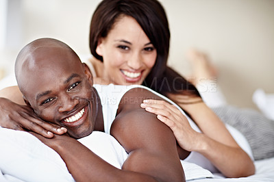 Buy stock photo Portrait of a smiling young couple lying in bed together