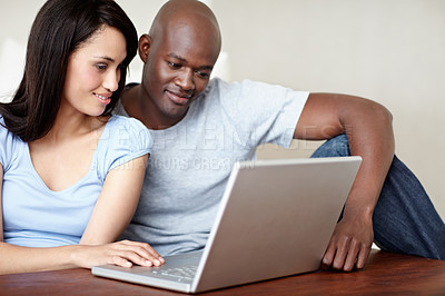 Buy stock photo Shot of a young couple using a laptop at home