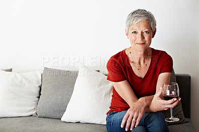 Buy stock photo Portrait of a smiling mature woman drinking wine in her living room