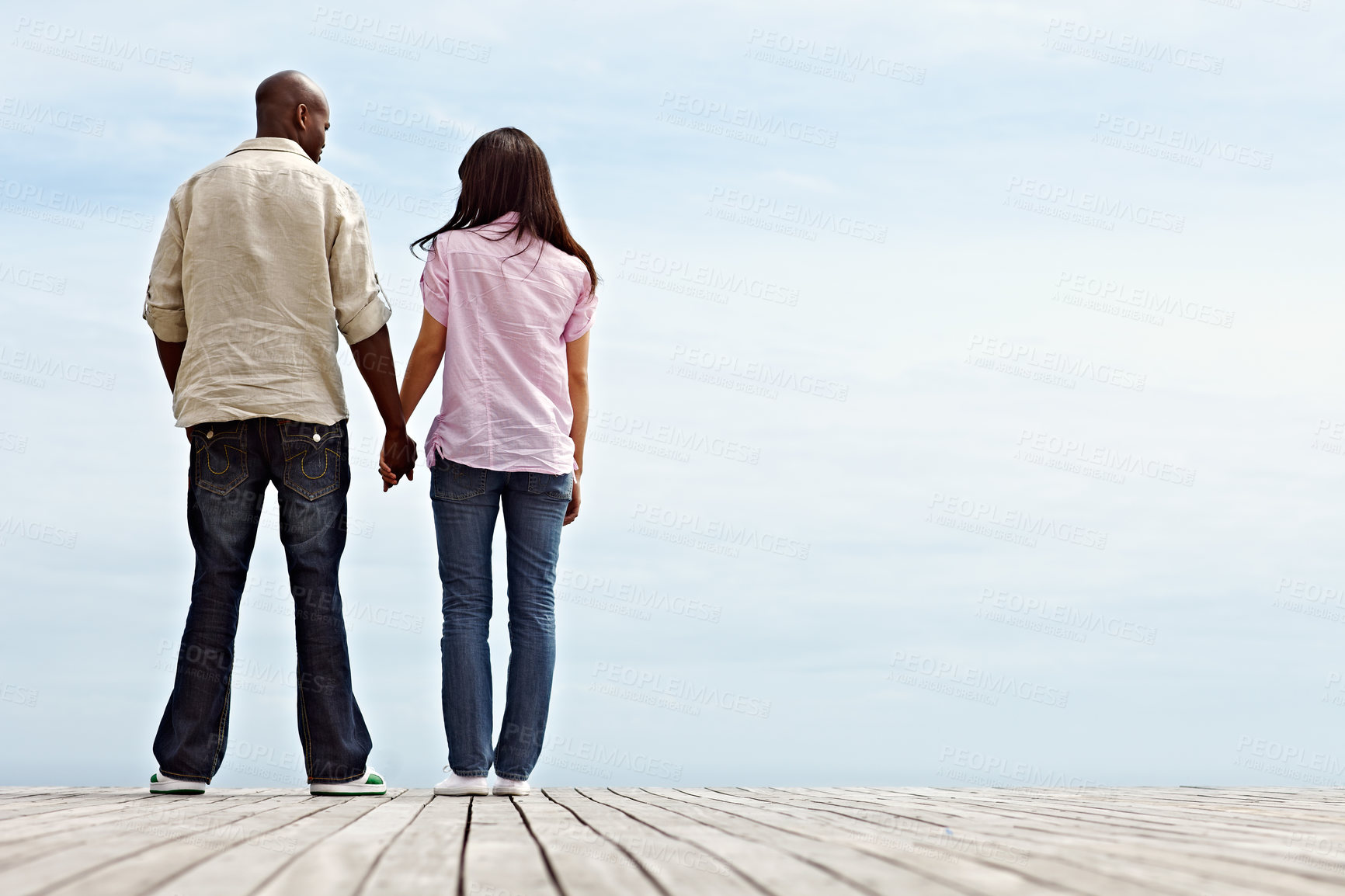 Buy stock photo Space, holding hands and back of couple by lake for holiday, vacation and travel on weekend. Nature, boardwalk and man with woman together for connection, relationship and affection with blue sky