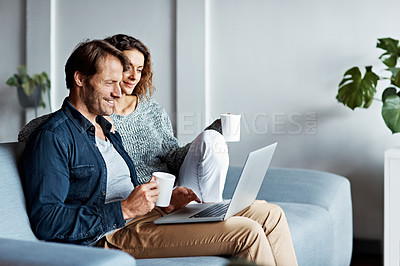 Buy stock photo Shot of a mature couple sitting on their sofa using a laptop