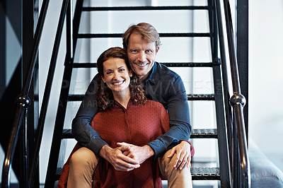 Buy stock photo Portrait of a smiling mature couple sitting on stairs in their loft