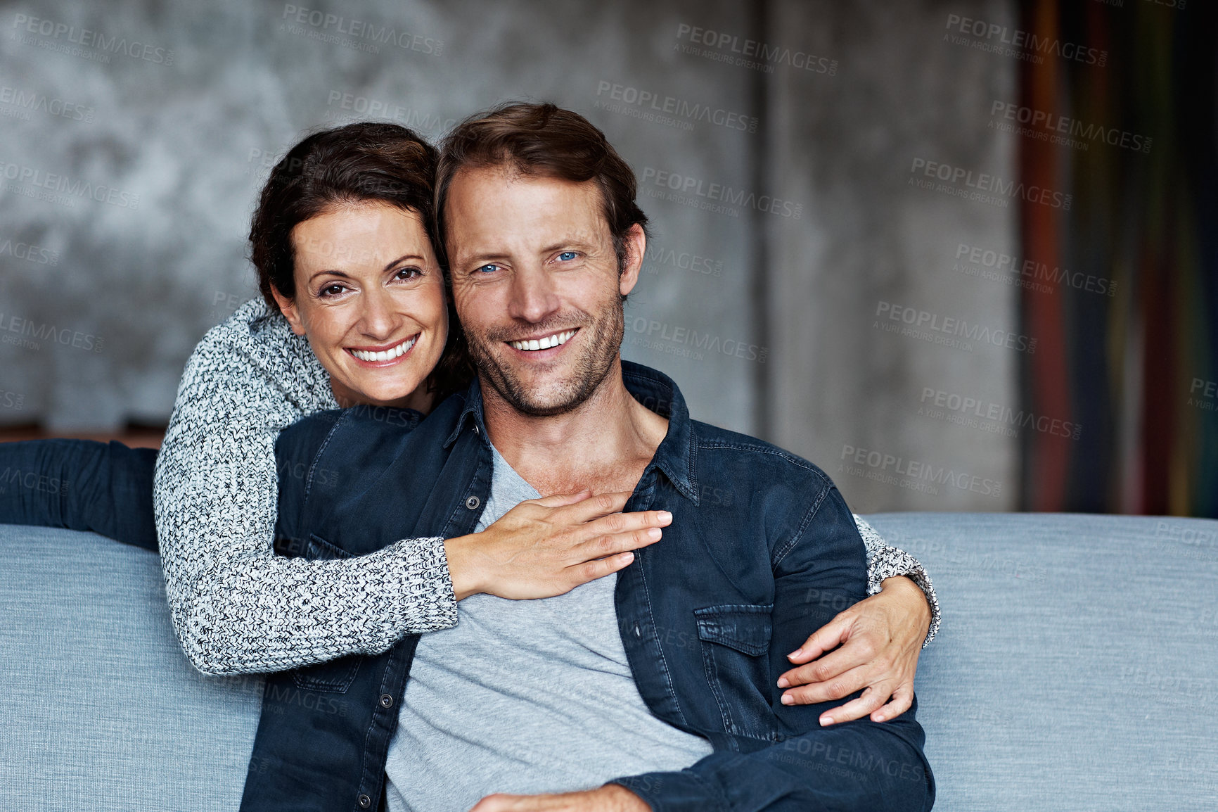 Buy stock photo Couple, relax and happy with hug in home for bonding together, healthy marriage or comfort. Security, woman and mature man with embrace on sofa for connection, relationship portrait or love affection