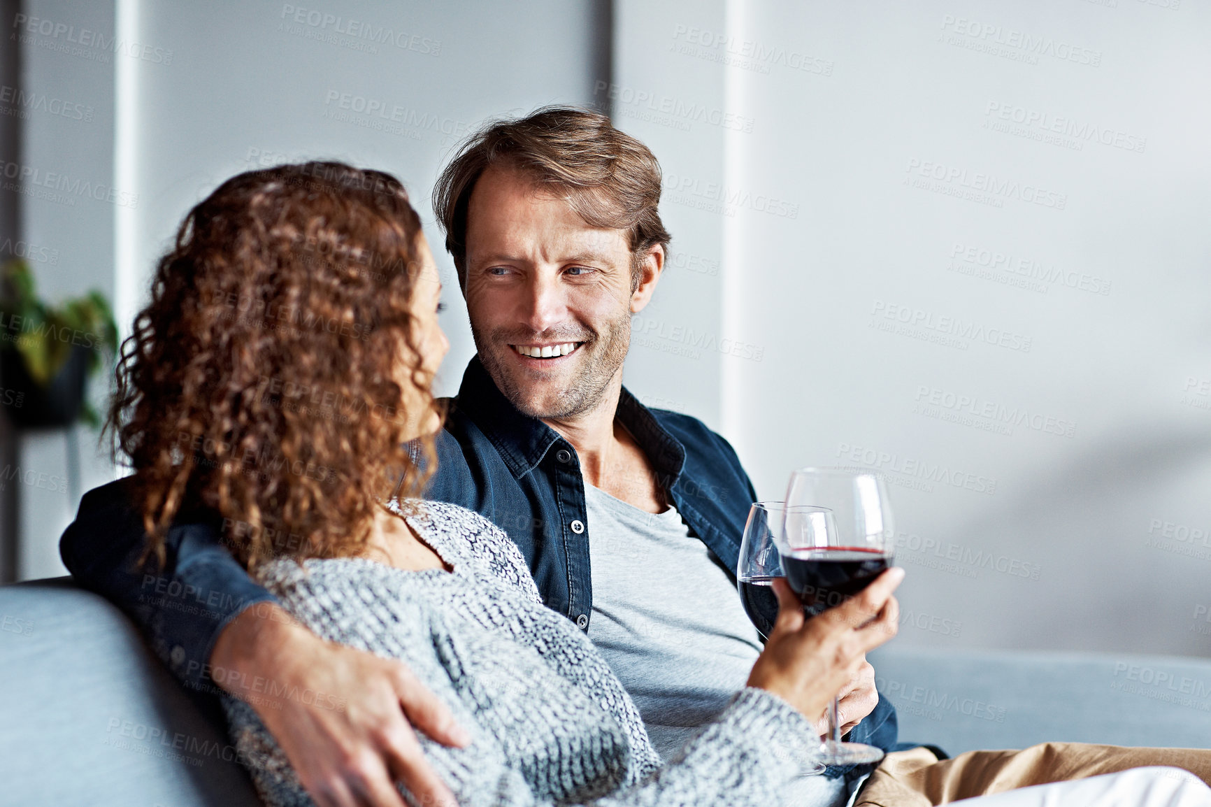 Buy stock photo Relax, wine and care with couple on sofa in home for bonding, weekend break and love connection. Alcohol drink, support and commitment with man and woman with glass in living room in house for smile