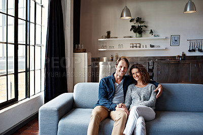 Buy stock photo Portrait of a content mature couple sitting on their living room sofa