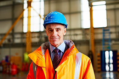 Buy stock photo Portrait of a mature man in workwear standing in a large industrial building