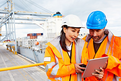 Buy stock photo Shot of two people talking over a digital tablet while standing on a large commercial dock