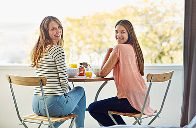 Buy stock photo Portrait of two friends eating breakfast together on a balcony