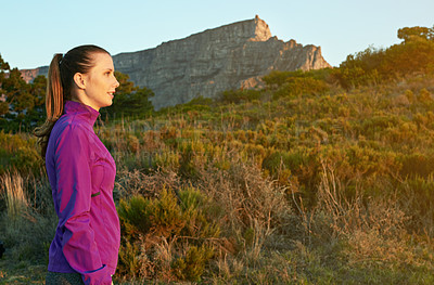 Buy stock photo Shot of a young woman admiring the scenery while out for a nature walk