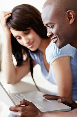 Buy stock photo Shot of a young couple using a laptop together at home
