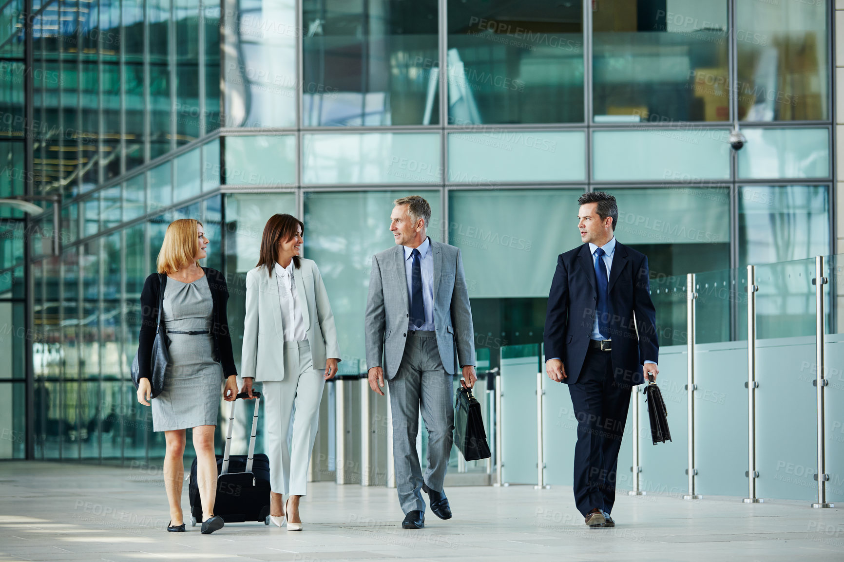 Buy stock photo Employee, team and happy people with suitcase in airport, conversation or international opportunity. Colleagues, walking and talk with luggage, mature lawyers and work trip for career development