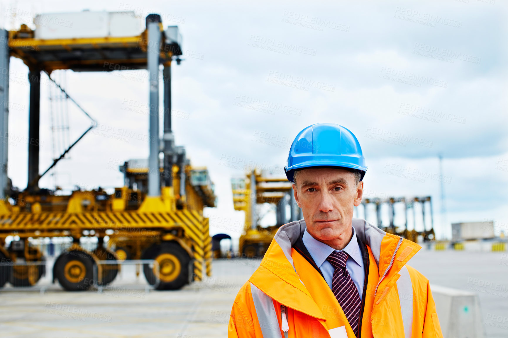 Buy stock photo Portrait of a mature man in workwear standing outside on a large commercial dock