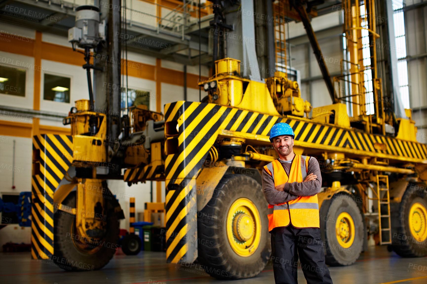 Buy stock photo Portrait of a man in workwear standing in front of a large truck in an industrial building