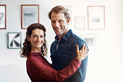 Buy stock photo Portrait of an affectionate couple standing arm in arm in their living room