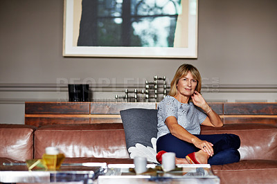 Buy stock photo Portrait of a mature woman relaxing on her living room sofa