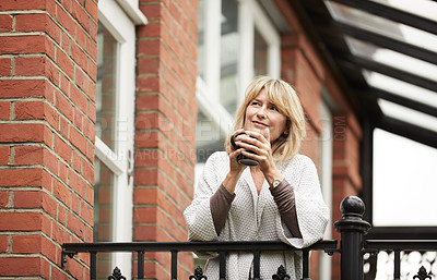 Buy stock photo Portrait of a mature woman leaning against the railing of her front porch drinking a coffee