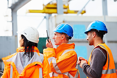 Buy stock photo Shot of three workers standing on a commercial dock